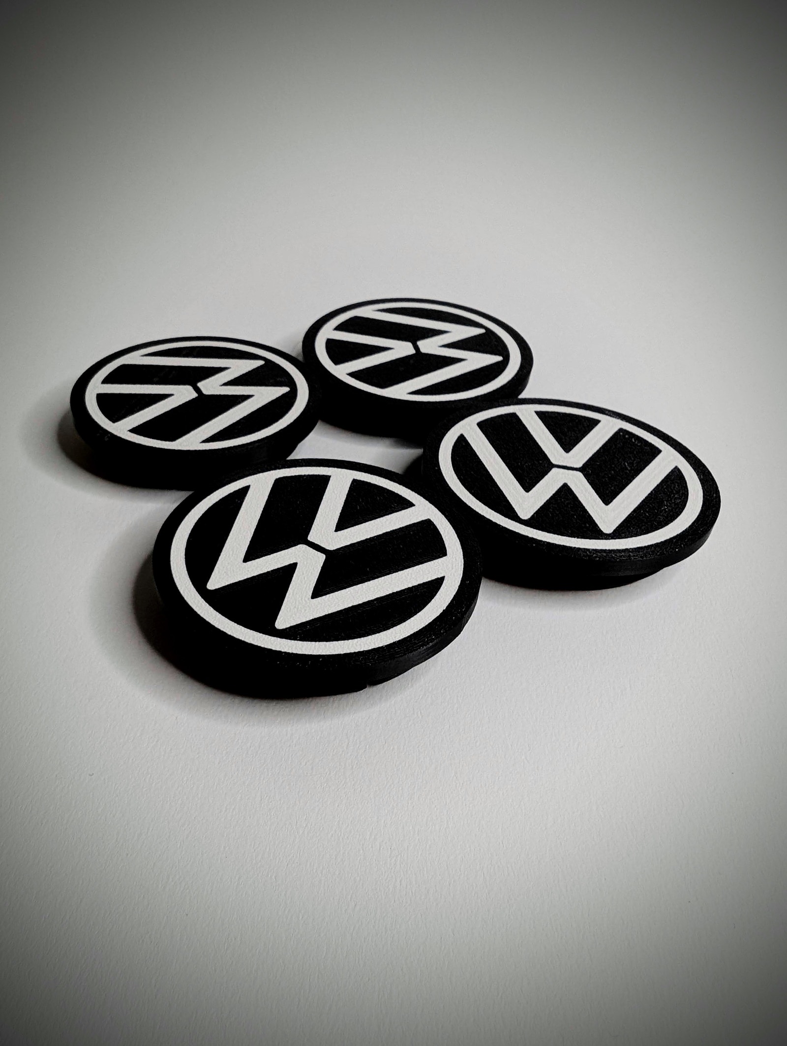 Sett med 4 senterkopper med VW-logo.